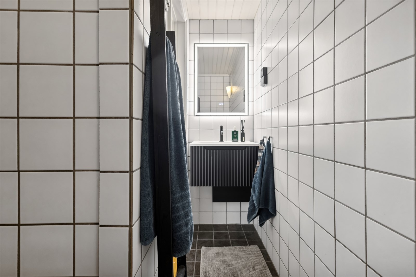 Leilighetens bad er fra 2005 og består av baderomsinnredning bestående av benkeskap med profilerte fronter. Speil med belysning over servant. Galleribilde