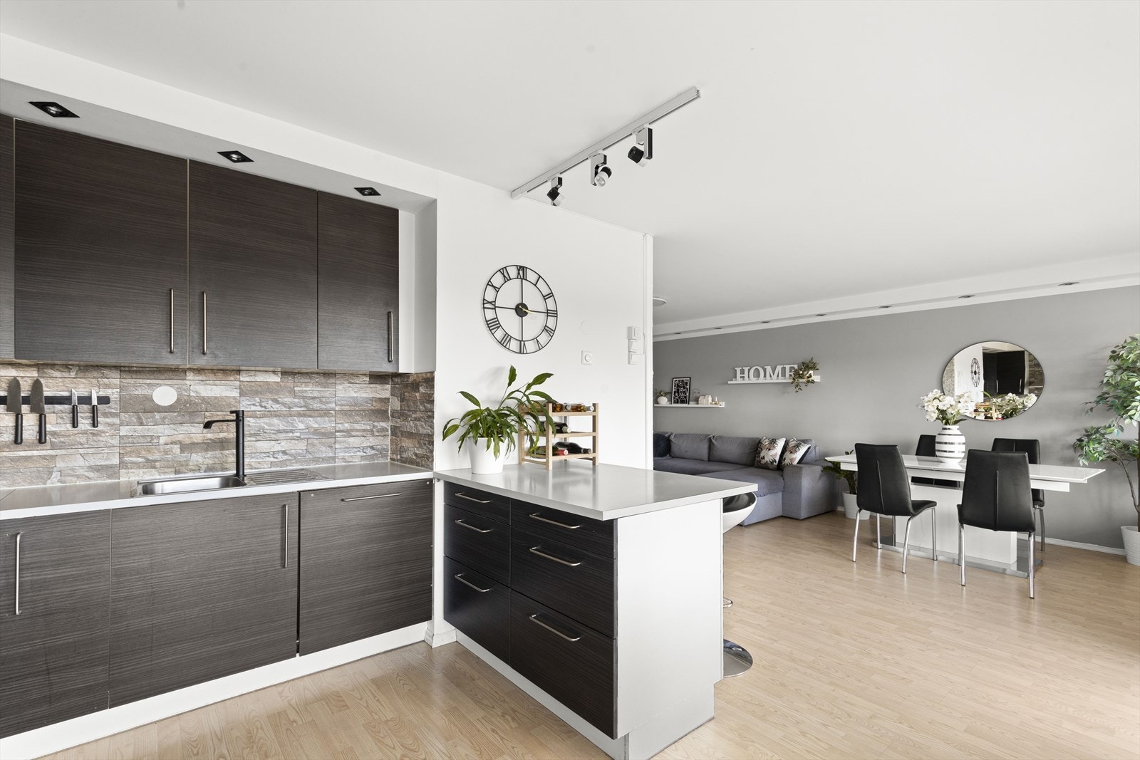 Pent HTH-kjøkken fra 2018 innredet med mørke fronter og benkeplate i laminat Galleribilde