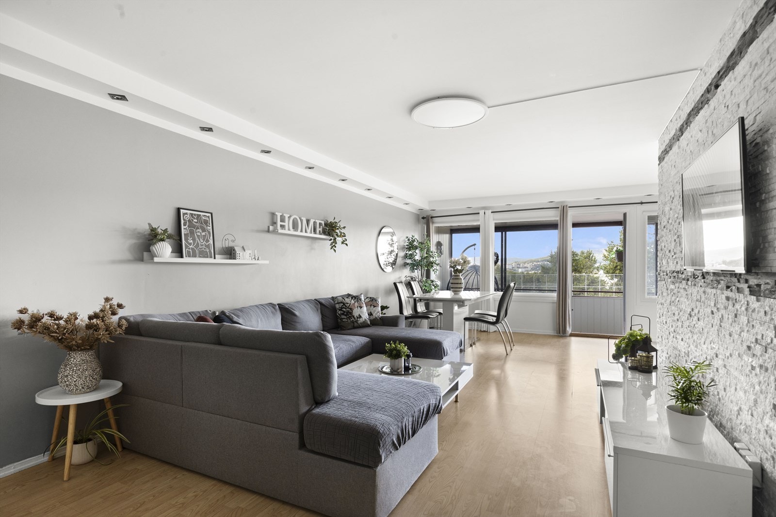 Lys stue med rikelig plass til en komfortabel sofagruppe, spisebord og annet ønsket møblement Galleribilde