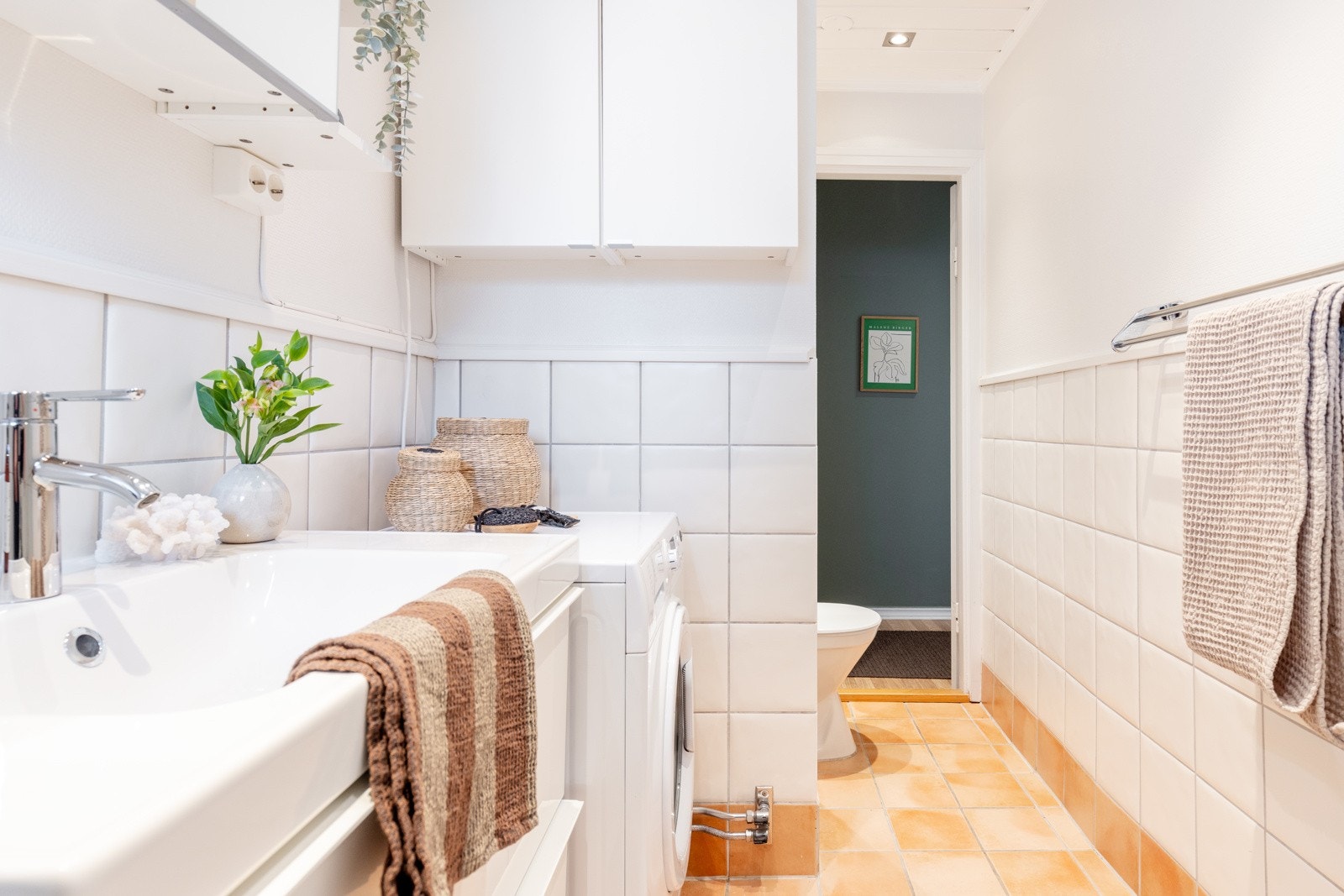 Badet har blant annet vegghengt servantinnredning, speilskap med overbelysning, toalett og opplegg for vaskemaskin. Galleribilde