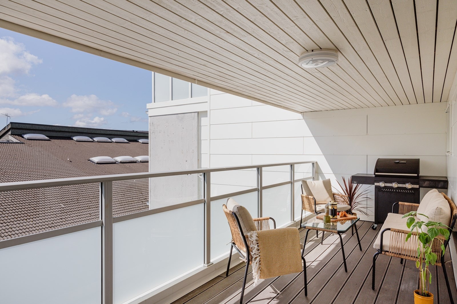 Dekket er bekledd med vedlikeholdsfrie terrassebord og rekkverk av glass og aluminium. Praktisk takoverbygg slik at altanen kan brukes hele året. Galleribilde