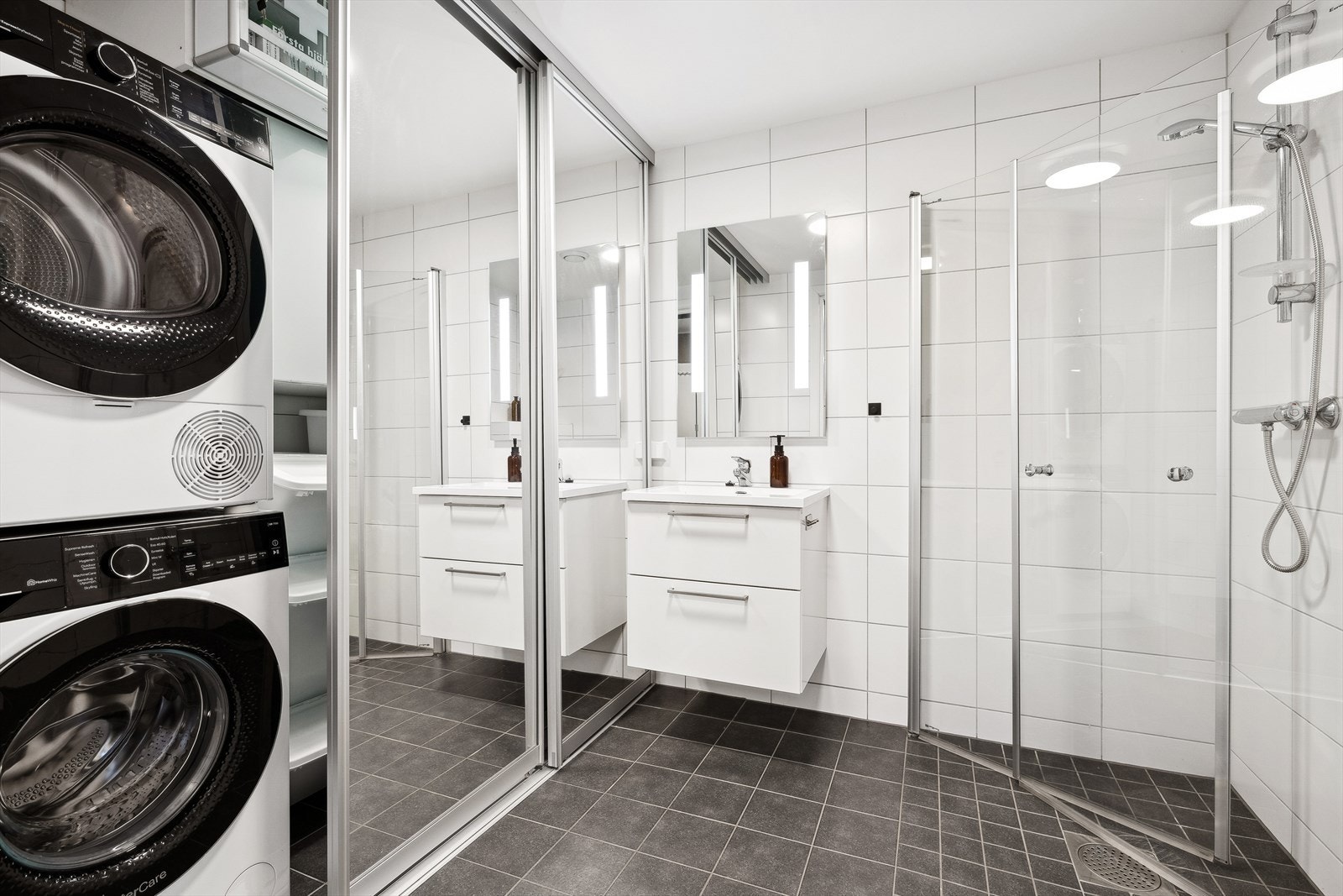 Bad/vaskerom i første etasje. Rommet er innredet med helstøpt servant med tilhørende innredning for oppbevaring, i tillegg til et moderne vegghengt klosset. Det er også tilkoblingsmuligheter for vaskemaskin og tørketrommel, samt et praktisk dusjhjørne. Galleribilde