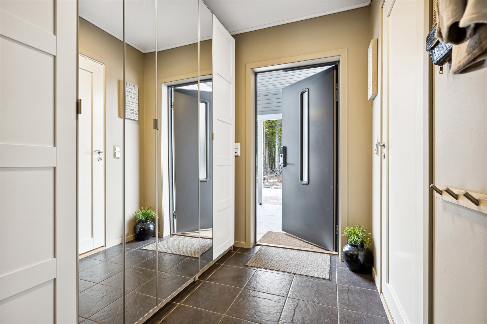 Entreen har flislagt gulv og godt med oppbevaringsplass i en stor garderobeløsning. Galleribilde