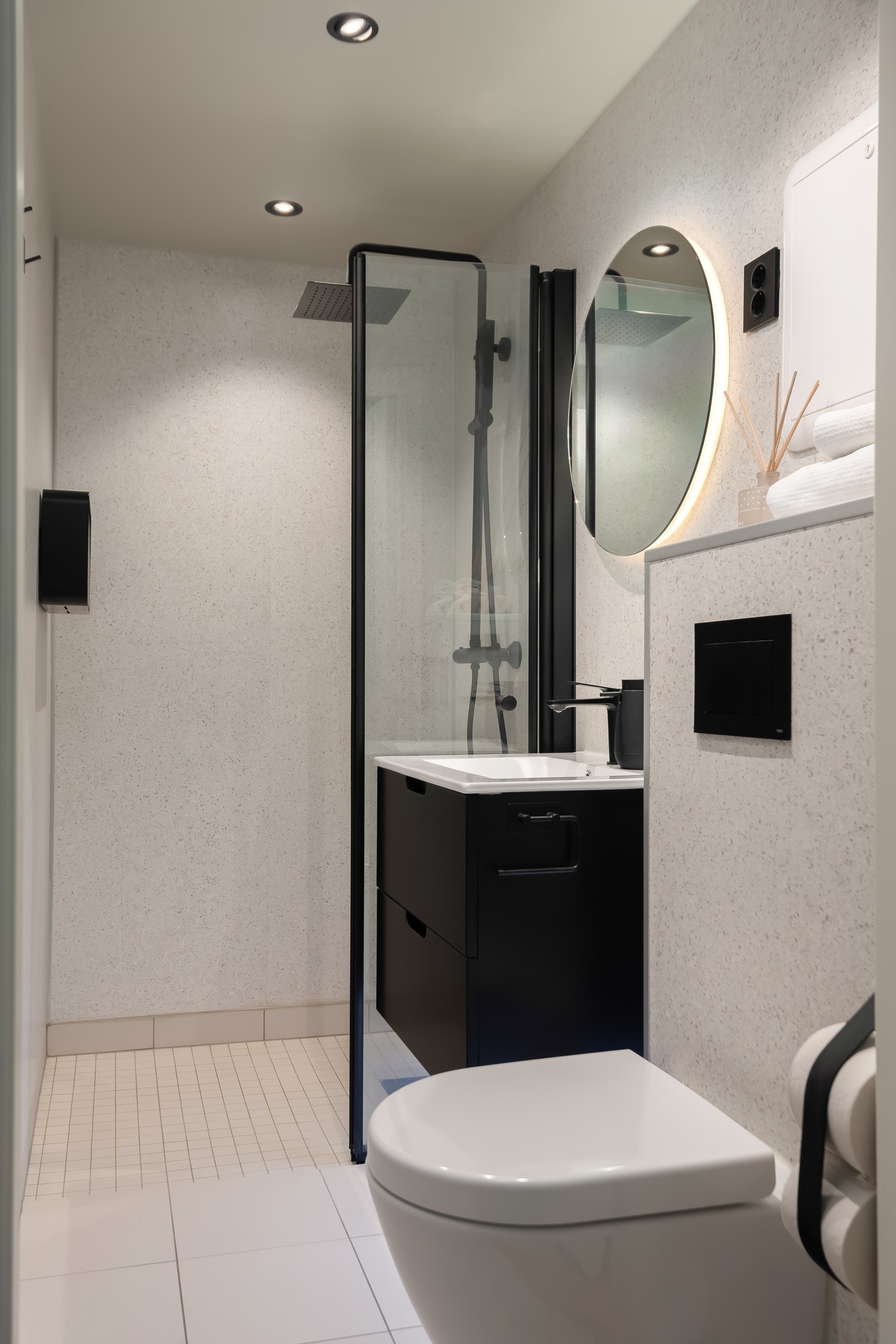 Gjennomført og moderne bad med blant annet smartbelysning, speil m/antidugg, varmekabler i gulv, vegghengt toalett og servantskap med belysning under. Galleribilde