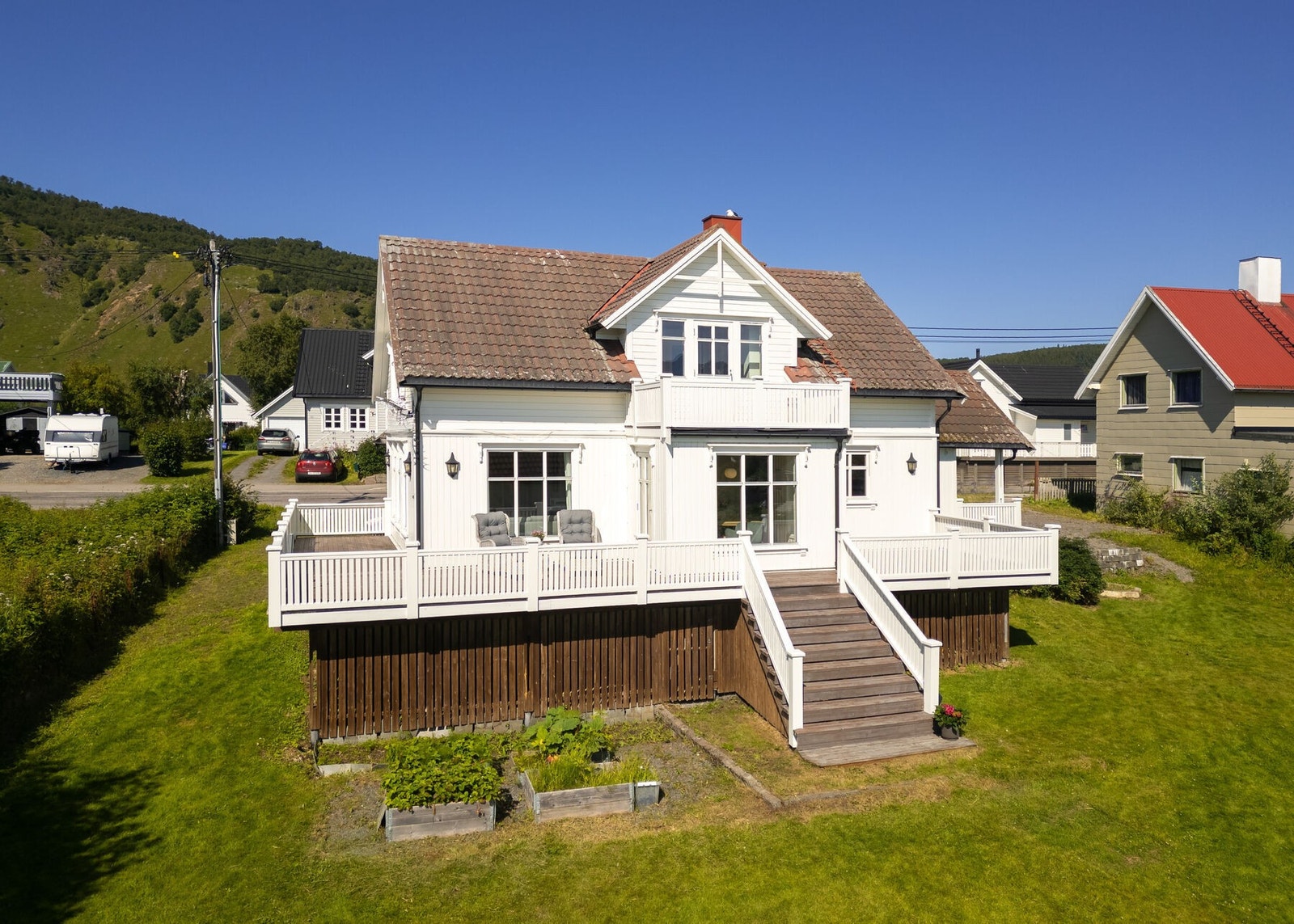 Uteområdet er opparbeidet med stort plenområde og diverse beplantning. Romslig terrasse med trapp til terreng. Galleribilde