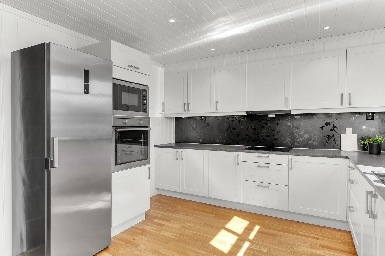 Kjøkkenet har en tidløs innredning med delvis integrerte hvitevarer og plass til frittstående kjøleskap. Galleribilde