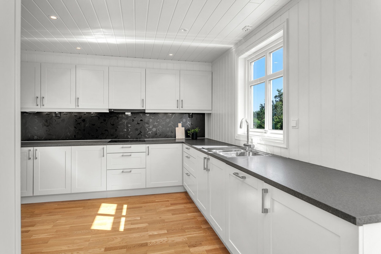 Romslig kjøkken med spotbelysning i tak, og rikelig skap- og benkeplass. Galleribilde