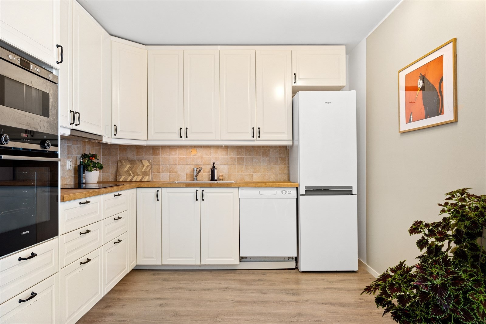 Kjøkkeninnredning fra Ikea med hvite fronter og benkeplate med kjøkkenvask Galleribilde