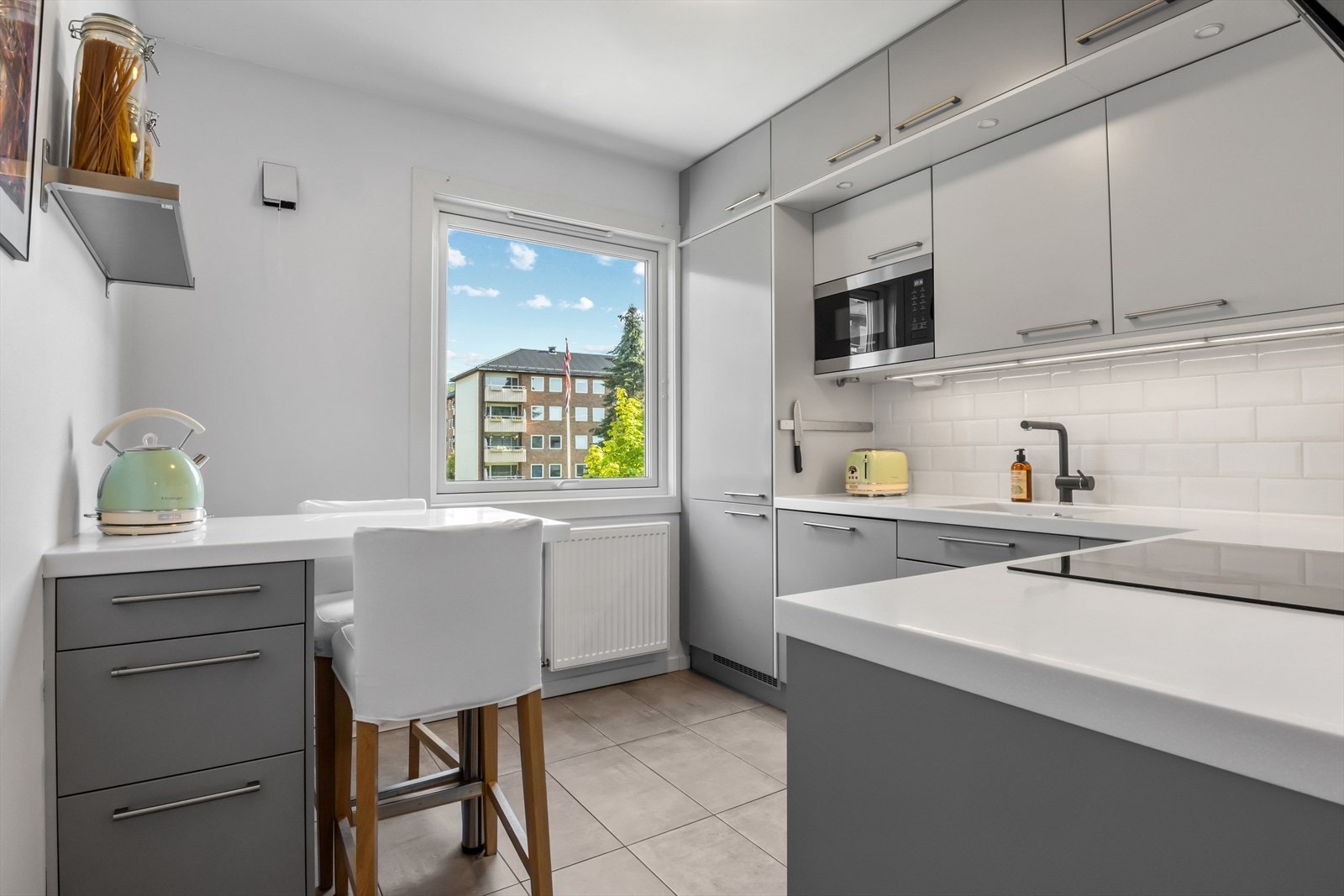 Integrerte hvitevarer samt en koselig spiseplass med oppbevaring under. Galleribilde