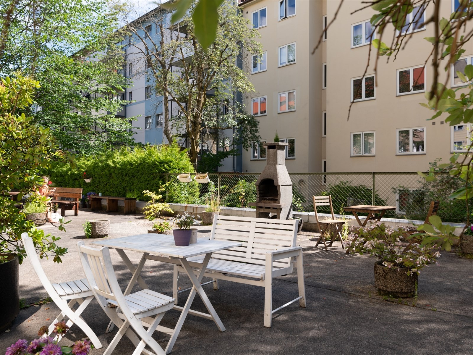 Hyggelig bakgård med flere sittegrupper og grill Galleribilde