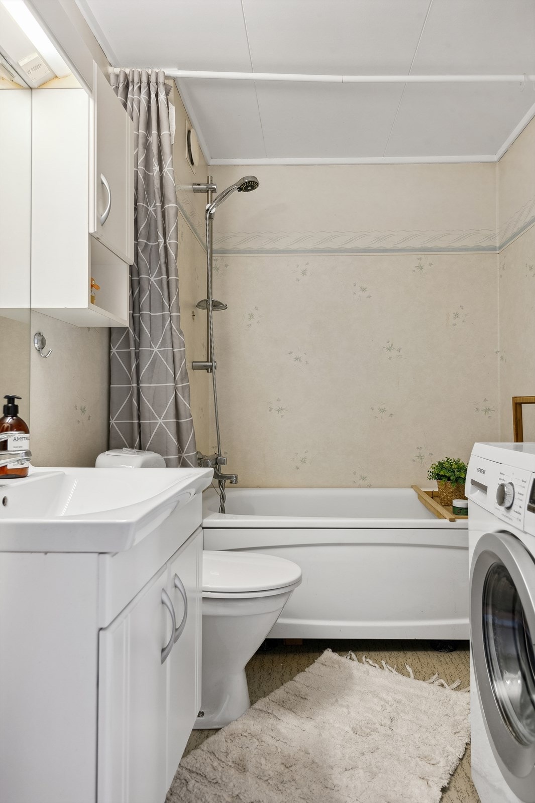 Baderom i andre etasje har belegg på vegger og gulv. Himlingsplater i taket. Baderomsinnredning med profilerte fronter. Heldekkende servant med 1- greps servantarmatur. Badekar. Opplegg for vaskemaskin. Gulvmontert toalett. Stråleovn. Galleribilde