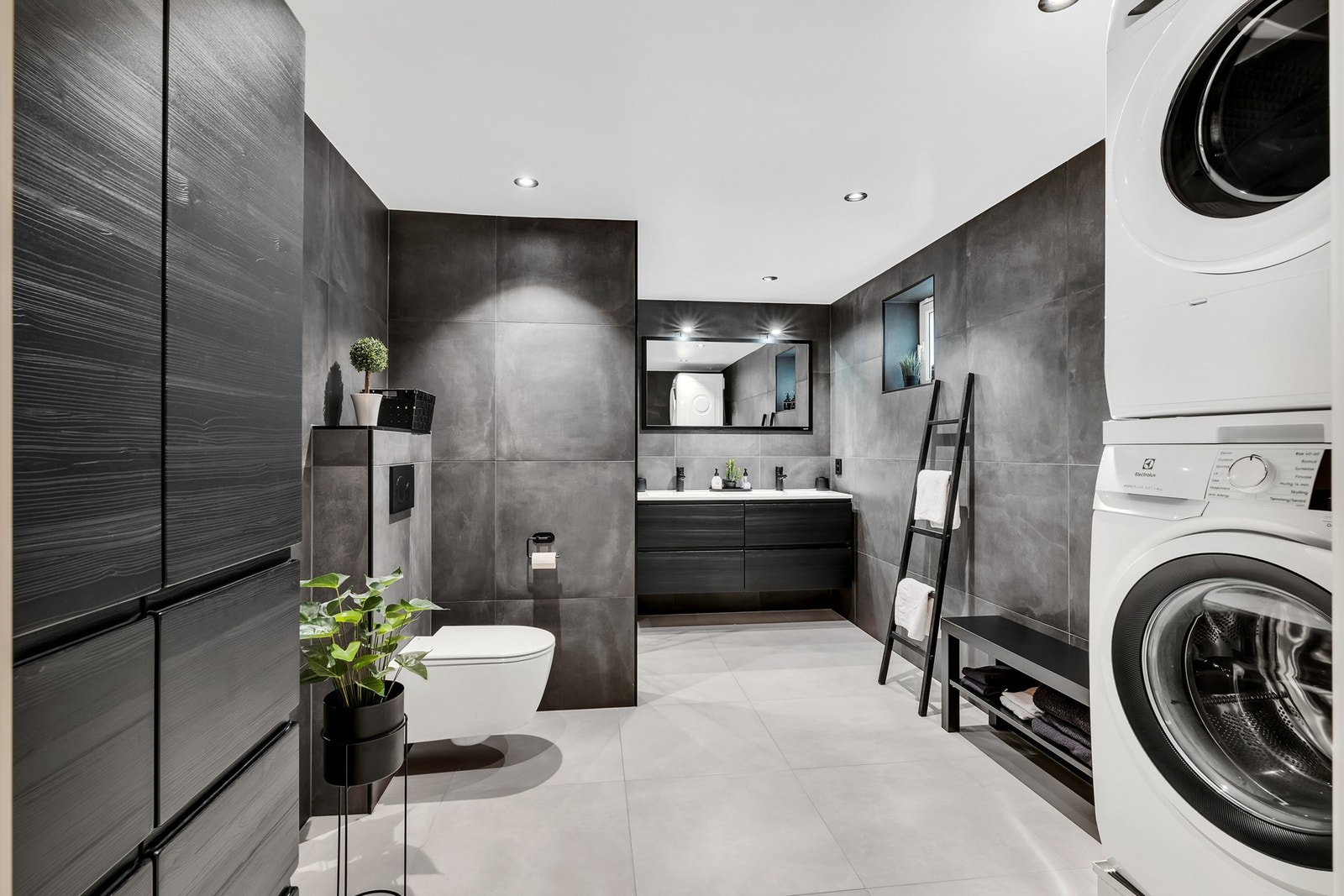 Svært lekkert bad i kjeller fra 2022. Badet er på hele 9,5 kvm og har 60x60-fliser, vegghengt toalett og opplegg for vaskemaskin/tørketrommel. Galleribilde