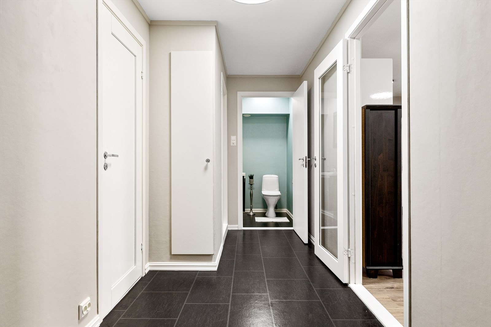 Når du entrer leiligheten, møtes du av en innbydende entré med belegg i flisemønster på gulvet og lune beige vegger. Her er det rikelig med plass til å henge fra seg yttertøy og sko. Galleribilde