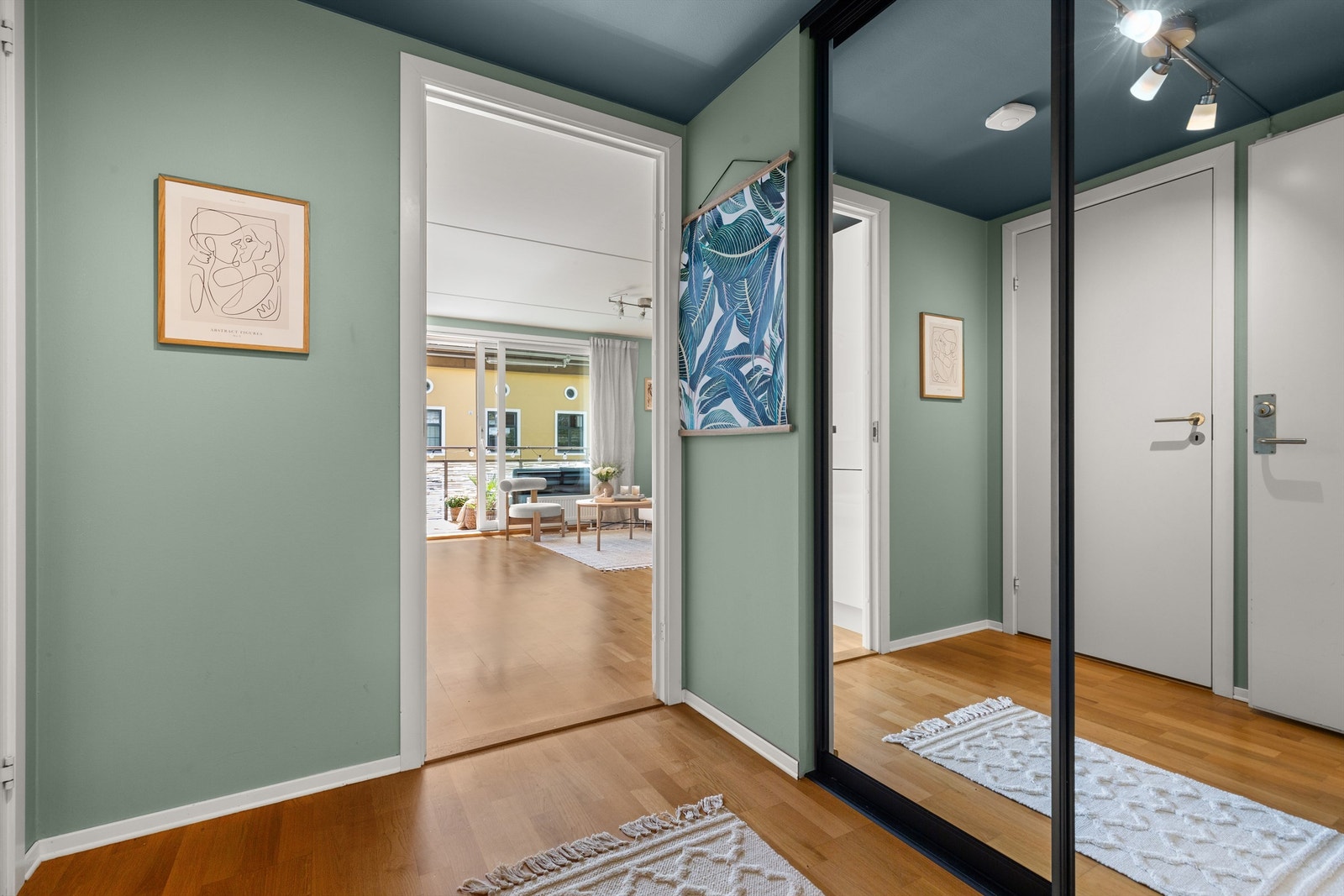 Velkommen inn! Leilighetens entré er lys og innbydende og gir et meget godt førsteinntrykk av boligen. Her er det god oppbevaringsplass i en romslig skyvedørsgarderobe med praktiske speilfronter. Galleribilde