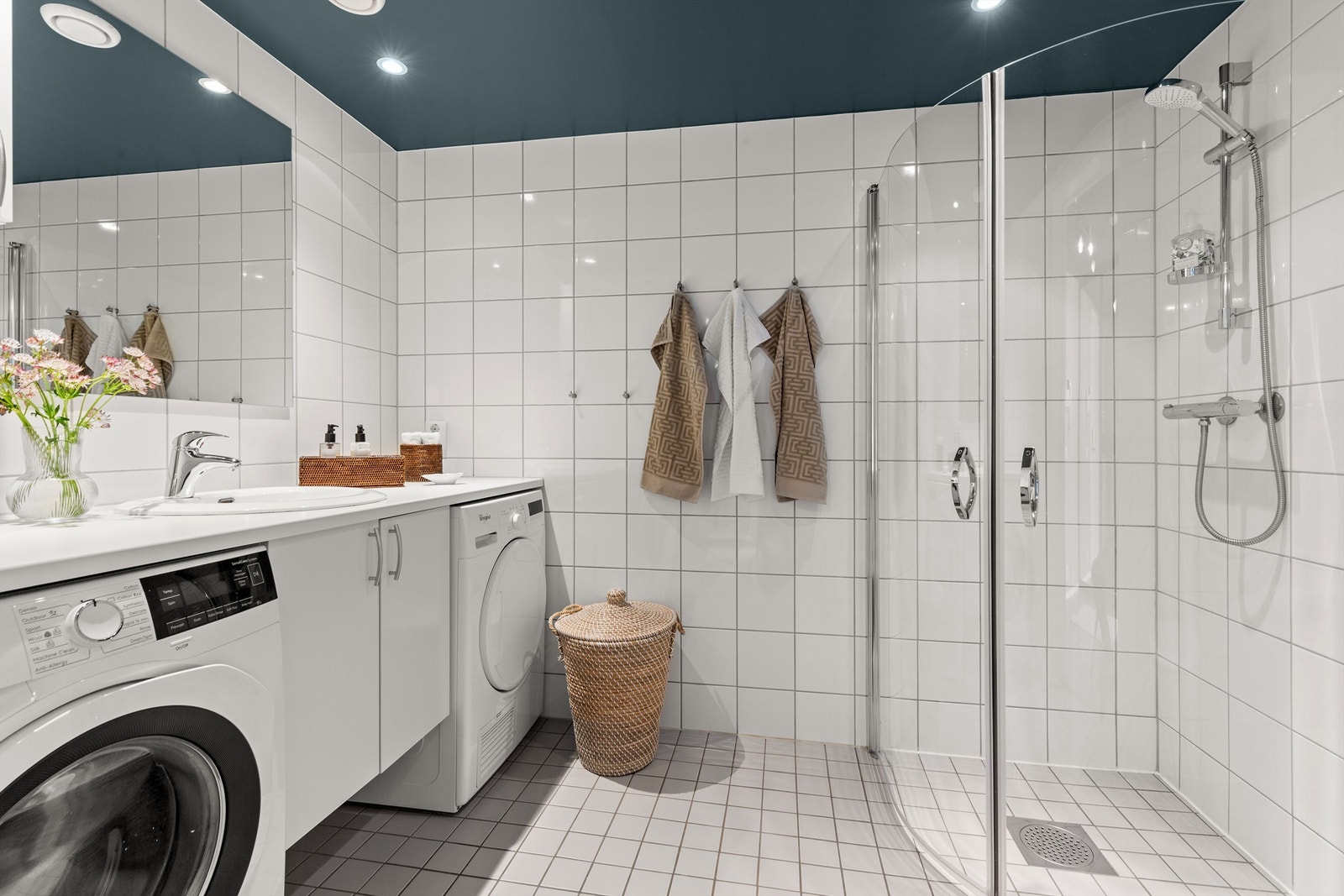 Badet er pent flislagt på gulv og vegger med varme i gulvet. Innredningen er fra HTH og består av vegghengt servantskap med nedfelt servant i porselen og benkeplate i laminat, samt veggskap. Galleribilde