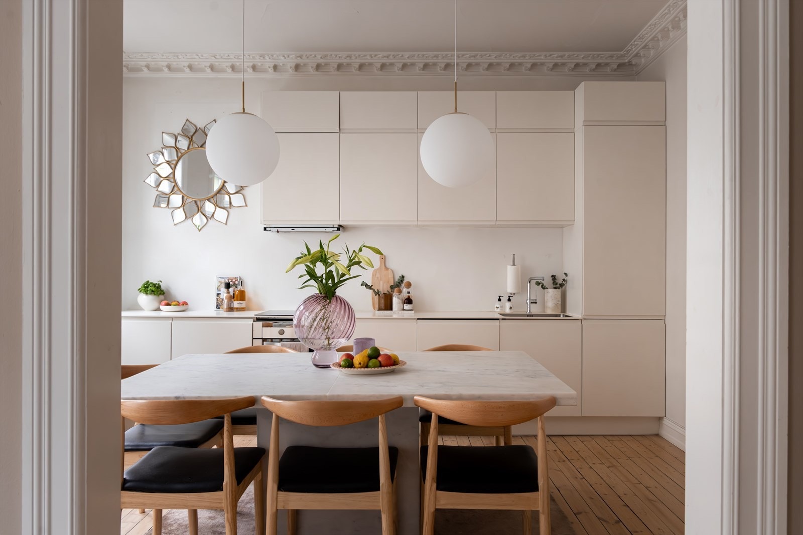 En bred døråpning mellom stuen og kjøkken gjør dette til et åpent og sosialt rom Galleribilde