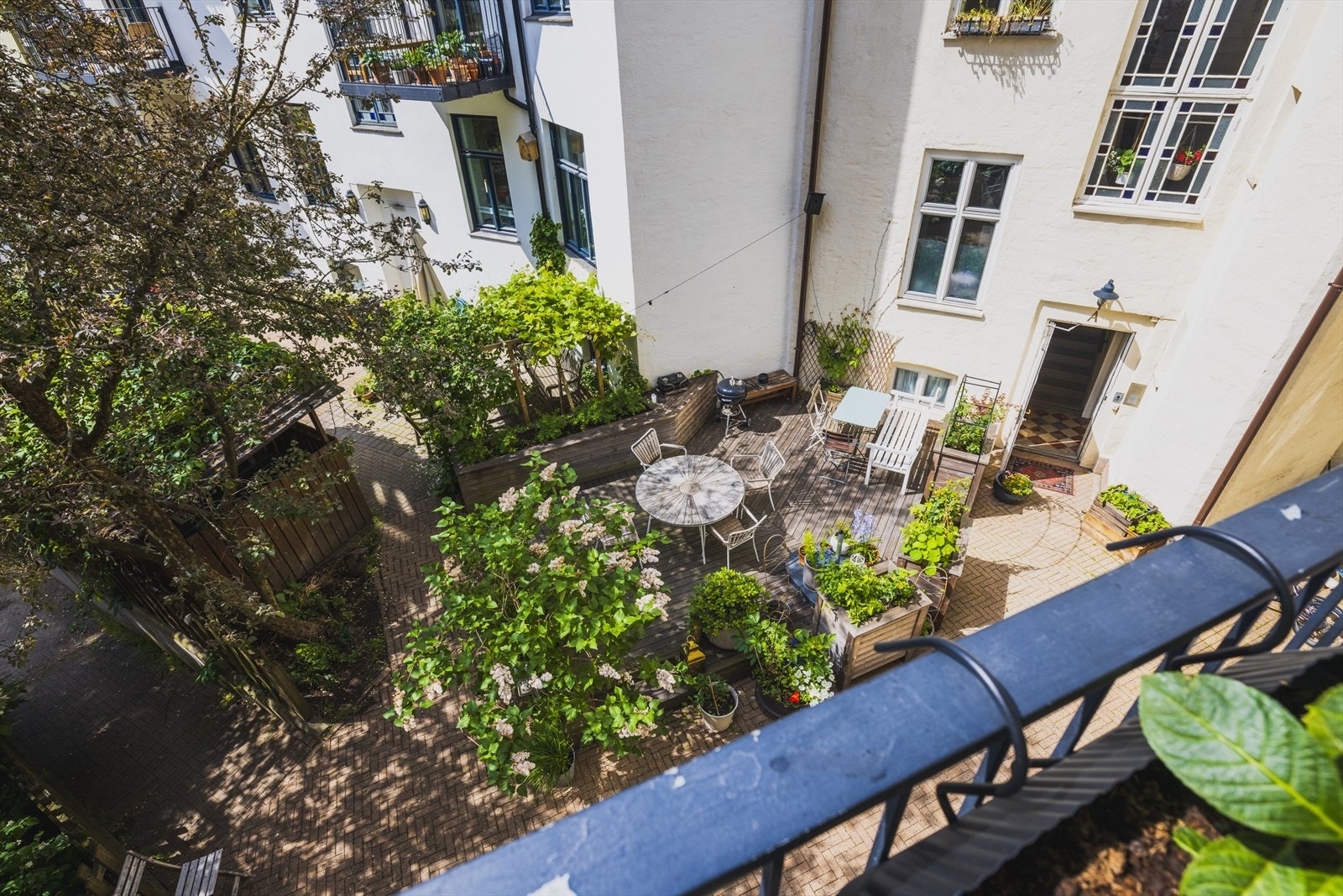 Fra balkongen har du også videre utsikt mot det grønne, frodige kvartalsgårdsrommet Galleribilde