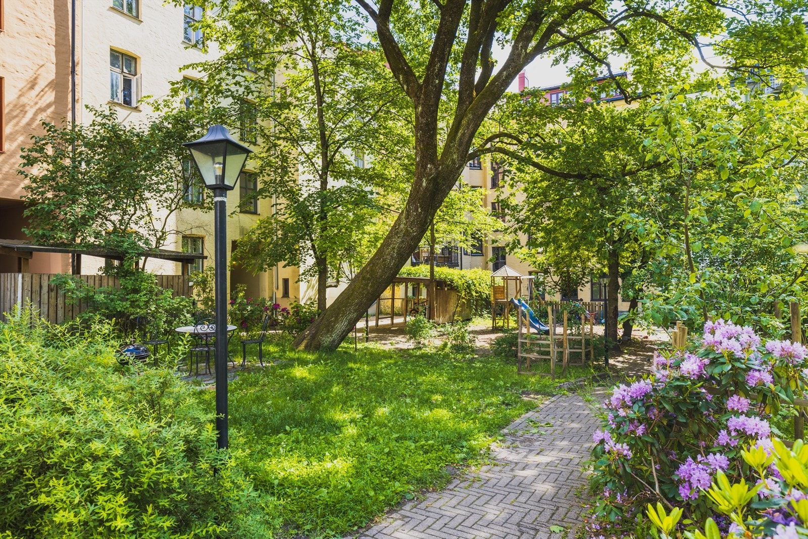 Et fantastisk kvartalsgårdsrom med plenareal, trær, prydbusker og stensatte gangveier. En grønn idyll til glede for både store og små! Galleribilde