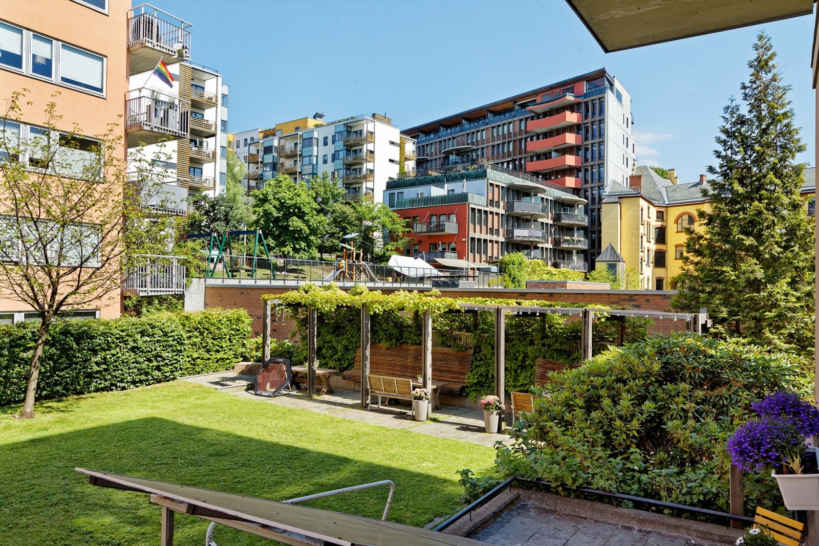 Utsikt. Nydelig pergola og flere sittegrupper tilhørende borettslaget i bakgården med umiddelbar nærhet til leiligheten. Galleribilde