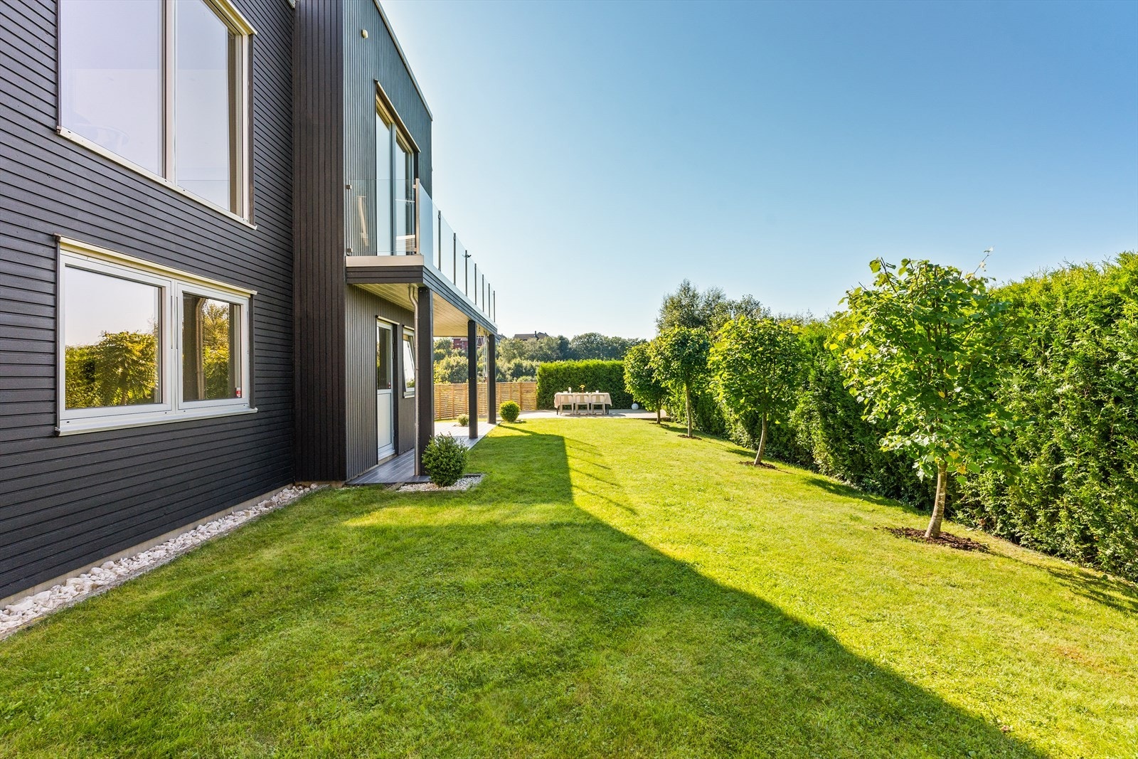 Hagen er skjermet og pent opparbeidet med terrassedekke, huskestativ og diverse prydebusker. Galleribilde