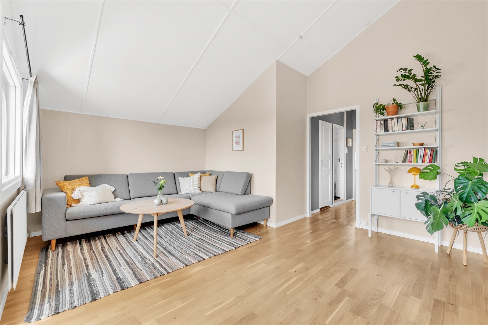 Romslig stue med parkett på gulv, malte vegger og malt tak. Her er det god plass for både sofagruppe og spisegruppe. Galleribilde