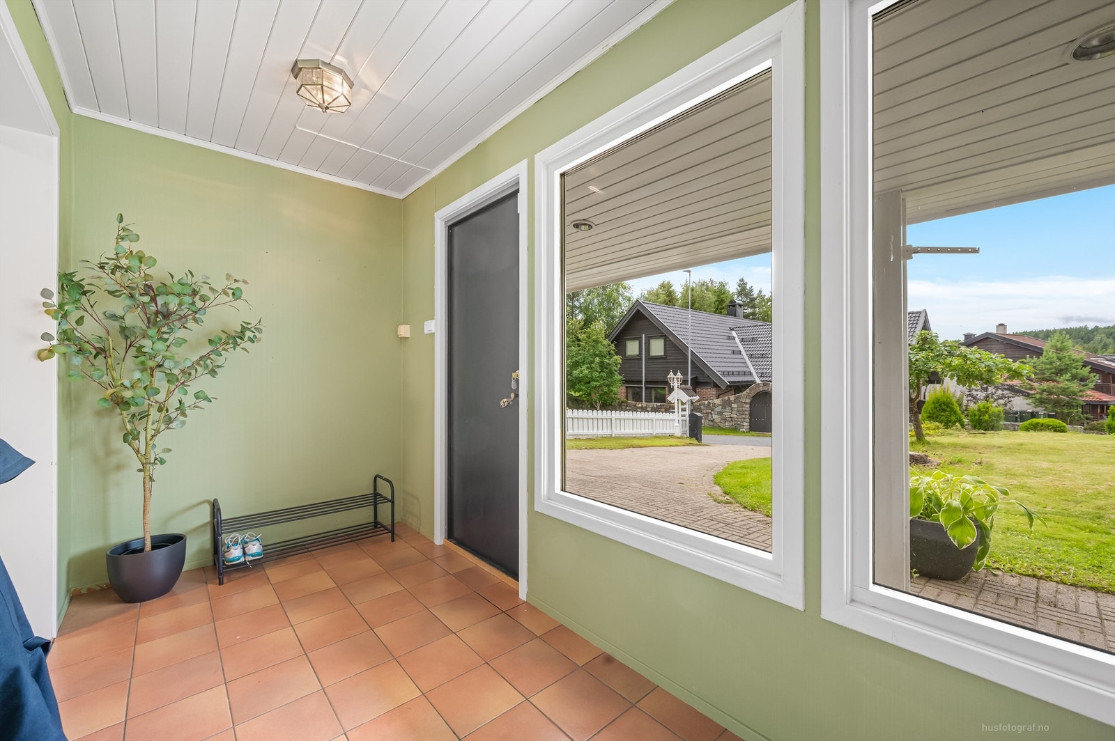 Entré med fliser på gulv, malte vegger og malt panel i himling Galleribilde