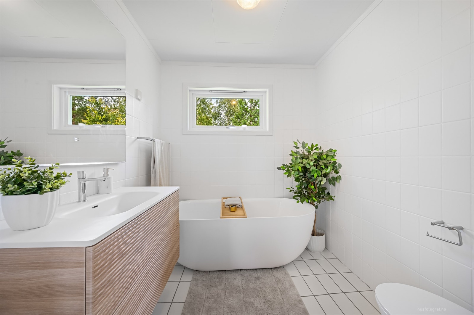 Flislagt bad med frittstående badekar og varmekabler i gulv Galleribilde