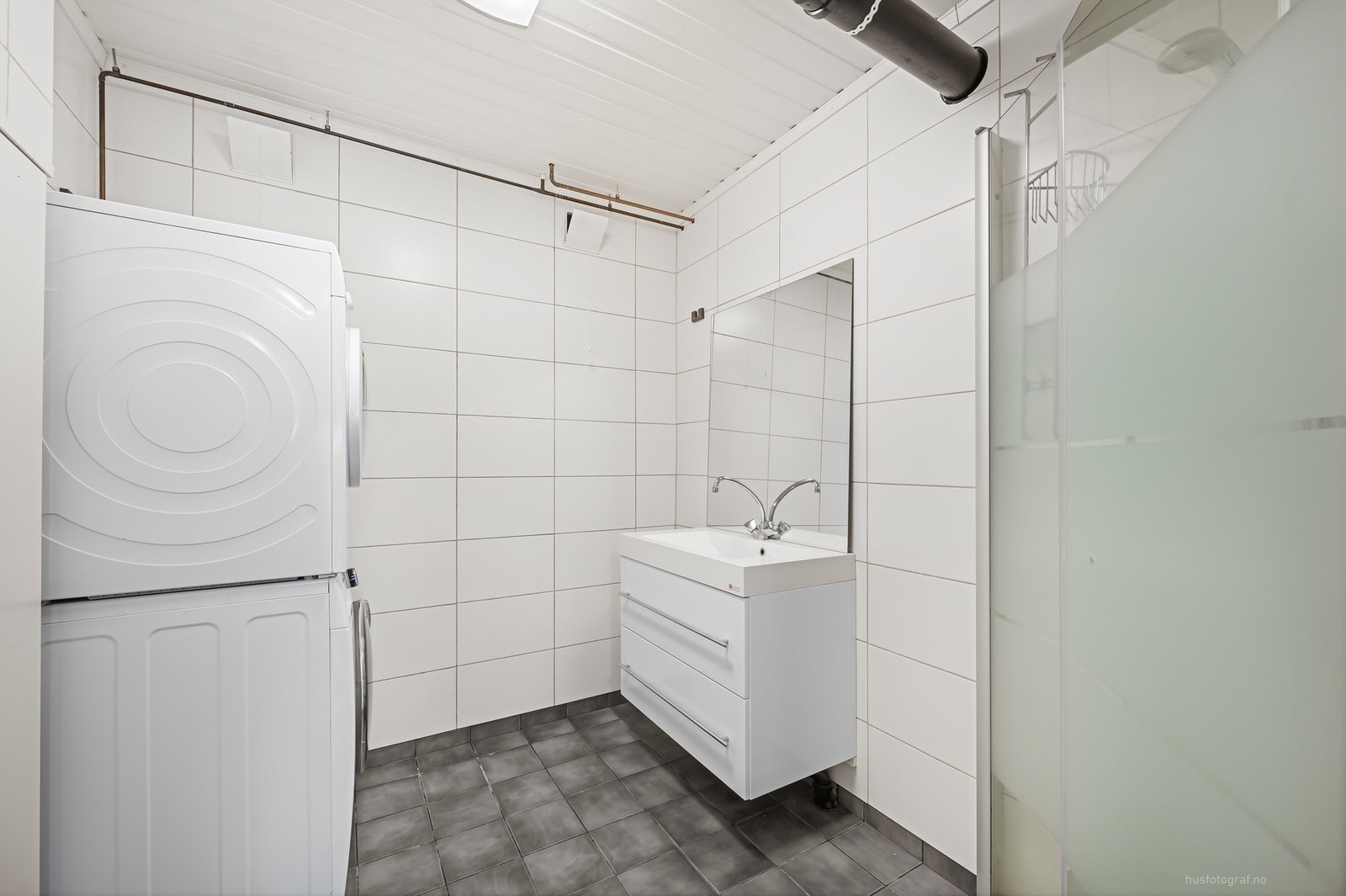 Badet har dusjhjørne med foldedører av glass Galleribilde