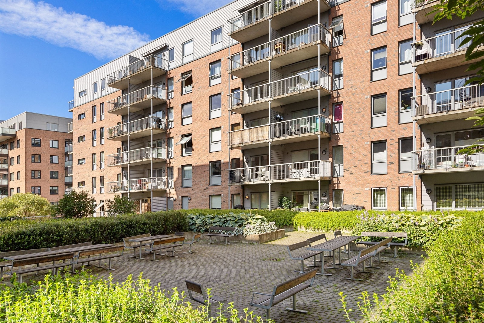Bakgården er opphøyd fra bakkenivå og byr på flere plasser man kan nyte fred og ro Galleribilde