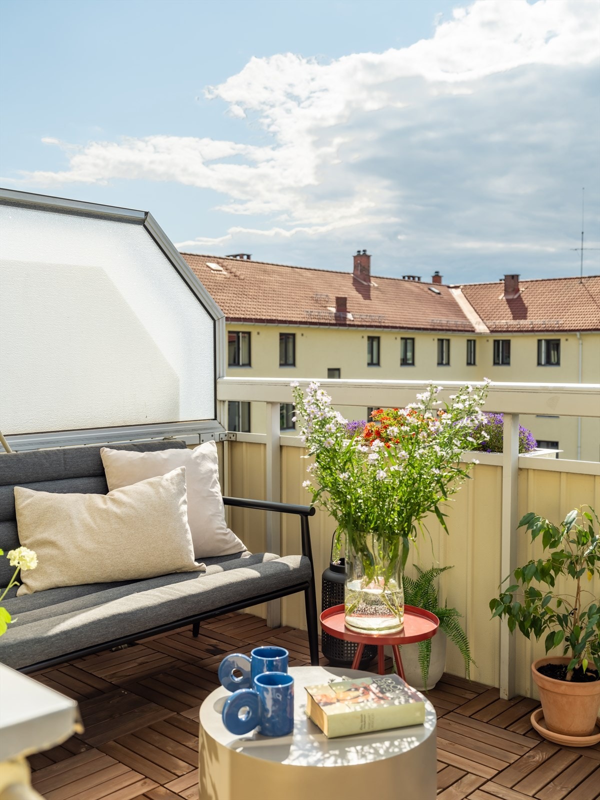 Balkongen har terrasseheller på gulv og stålrekkeverk, samt levegg som skjermer for innsyn fra naboer. Galleribilde