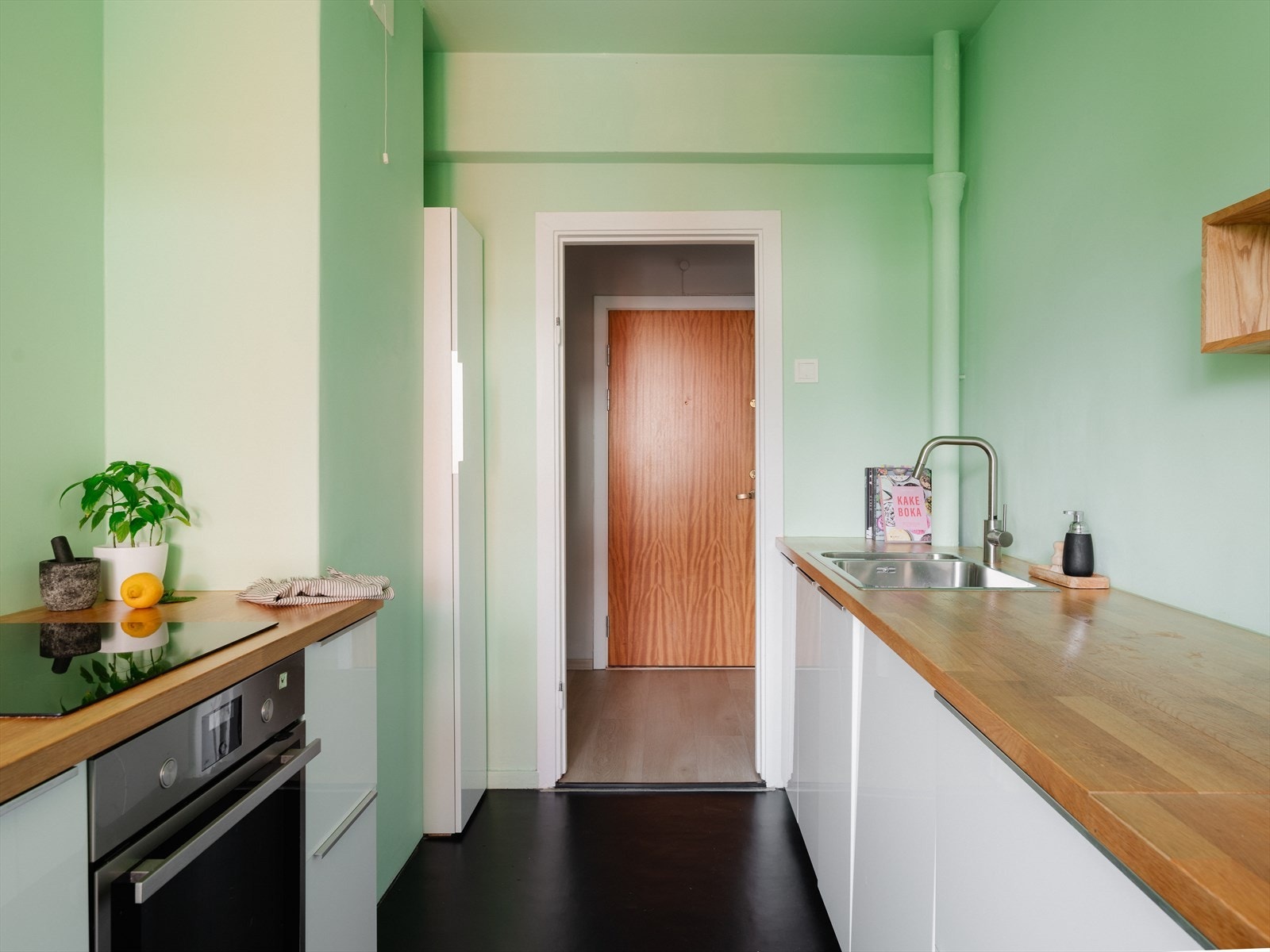 Kjøkkeninnredningen er fra IKEA med hvite fronter og benkeplate i tre. Galleribilde