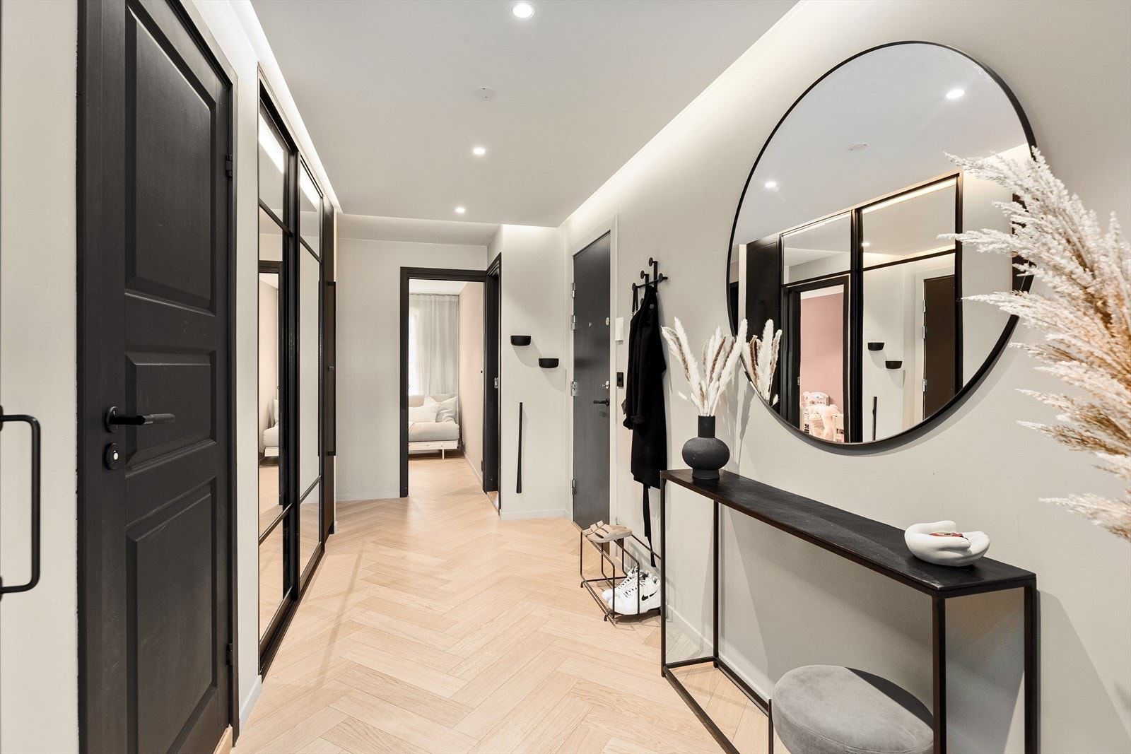 Romslig entré med god plass til å henge fra seg yttertøy og sette fra seg sko. Her er det også stor skyvedørsgarderobe med speilfronter Galleribilde