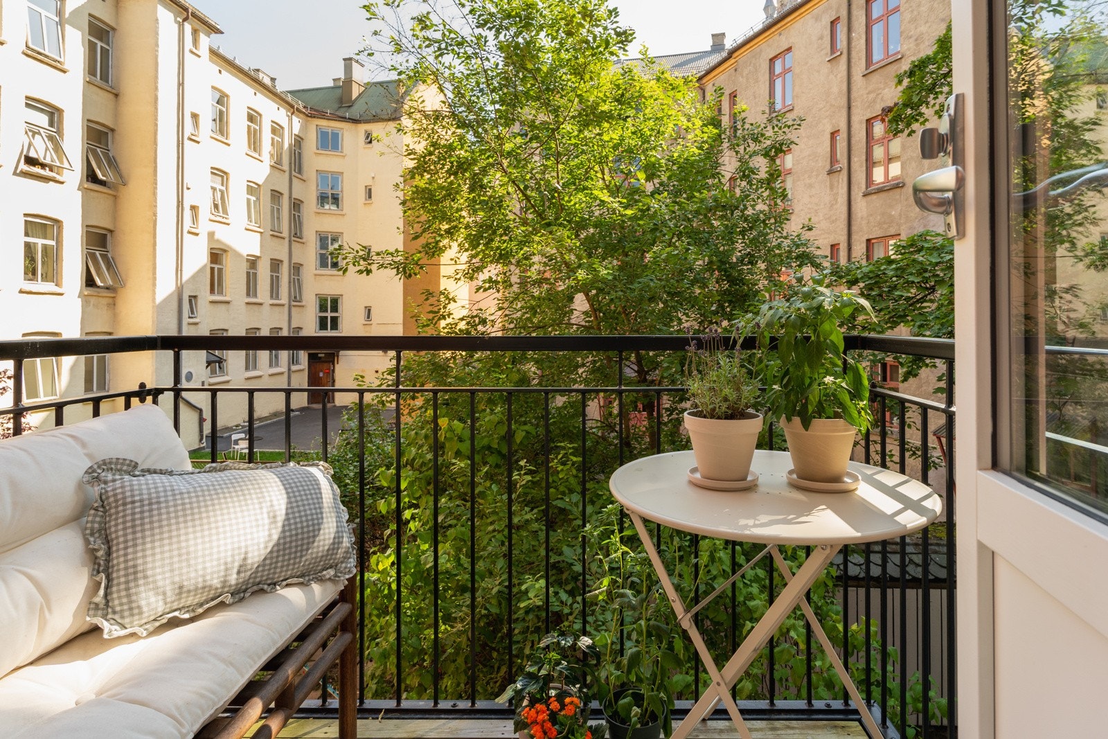 Solrik balkong vendt mot idyllisk gårdsrom. Galleribilde