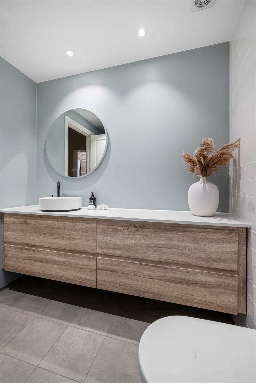 Badet er innredet med vegghengt toalett, stor baderomsinnredning og dusjnisje med regnfallsdusj. Galleribilde