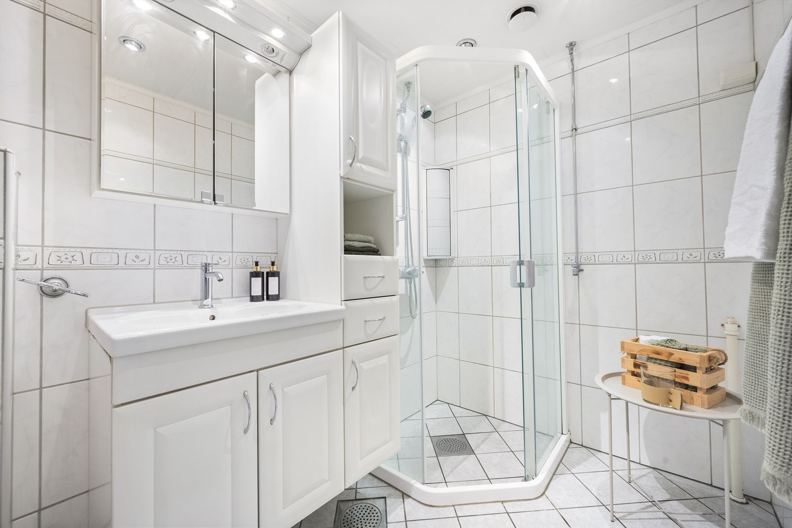 Badet er utstyrt med et veggmontert toalett, en servantinnredning, et dushjørne med innredning med glassdør, samt opplegg for vaskemaskin. Galleribilde