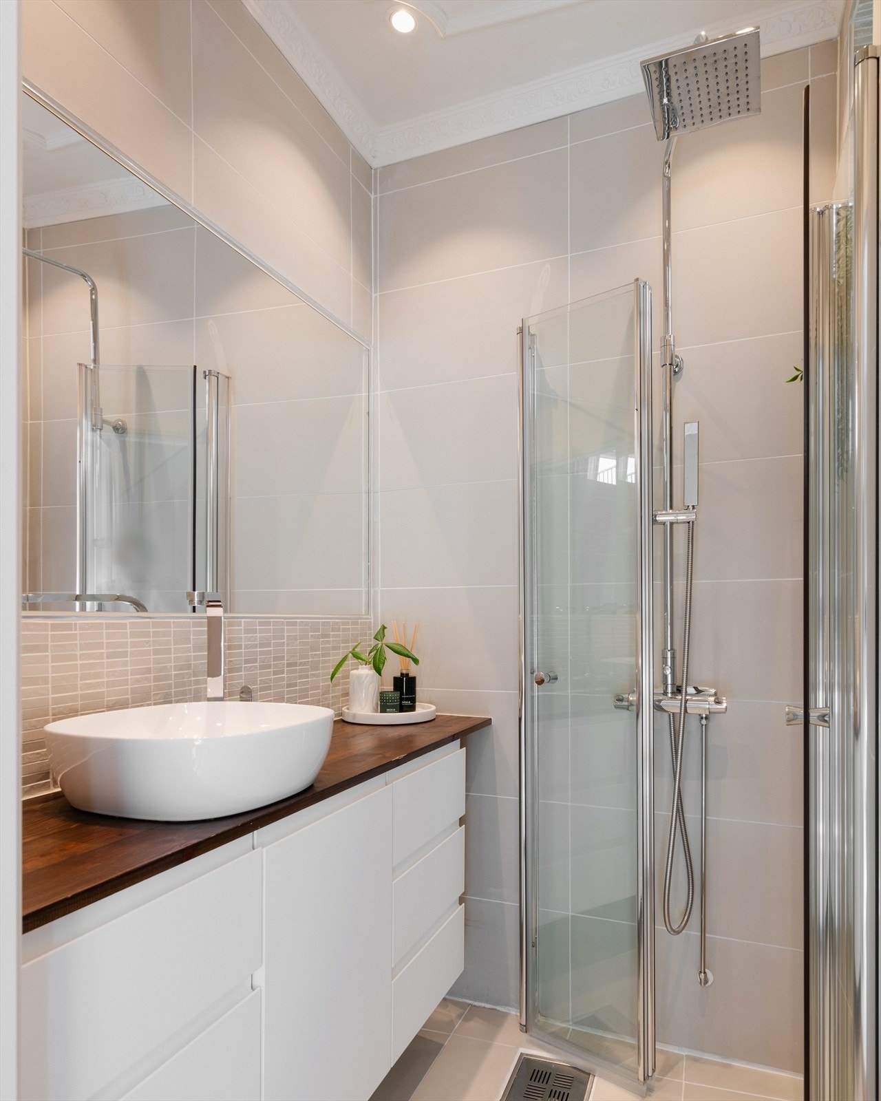 Badet består av servant med underskap, innfliset speil og inn-/utadslående dusjdører Galleribilde