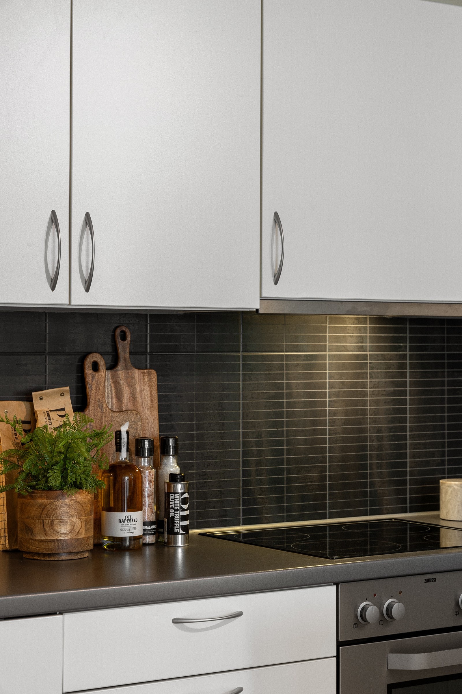 Mørke fliser som mellom benkeplate og overskap. Galleribilde