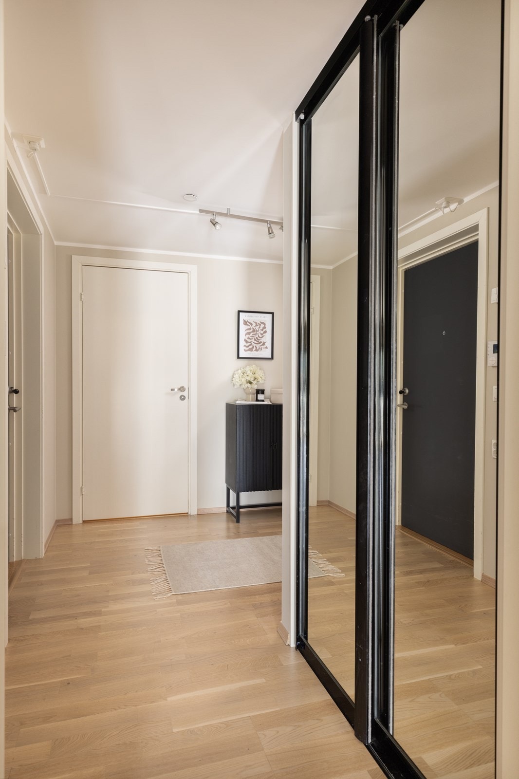 Leiligheten har en innbydende entré som skaper et umiddelbart godt førsteinntrykk. Det er god plass til oppbevaring av yttertøy i den romslige skyvedørsgarderoben. Galleribilde