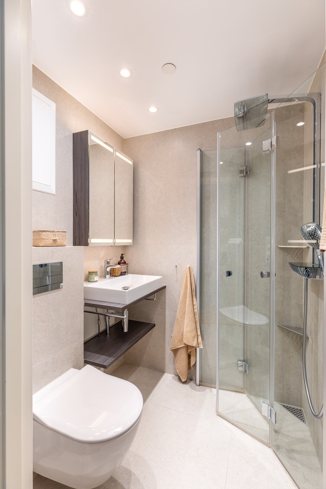 Baderom 2: Delikat flislagt baderom med innfelt downlights og elektrisk gulvvarme. Badet er innredet med vegghengt klosett, servant med innredning, speilskap m/lys, dusjhjørne med svingbare glassdører og håndkletørker med varme. Galleribilde
