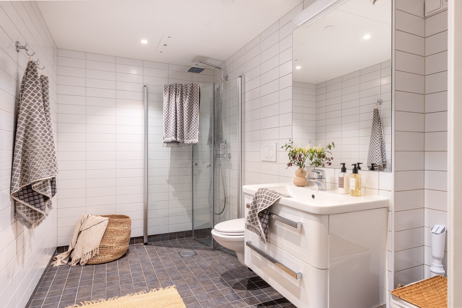 Baderom 1: Pent flislagt baderom med innfelt downlights og vannbåren gulvvarme. Badet er innredet med vegghengt klosett, servant med innredning og dusjhjørne med svingbare glassdører. Det er opplegg for vaskemaskin og balansert ventilasjon. Galleribilde