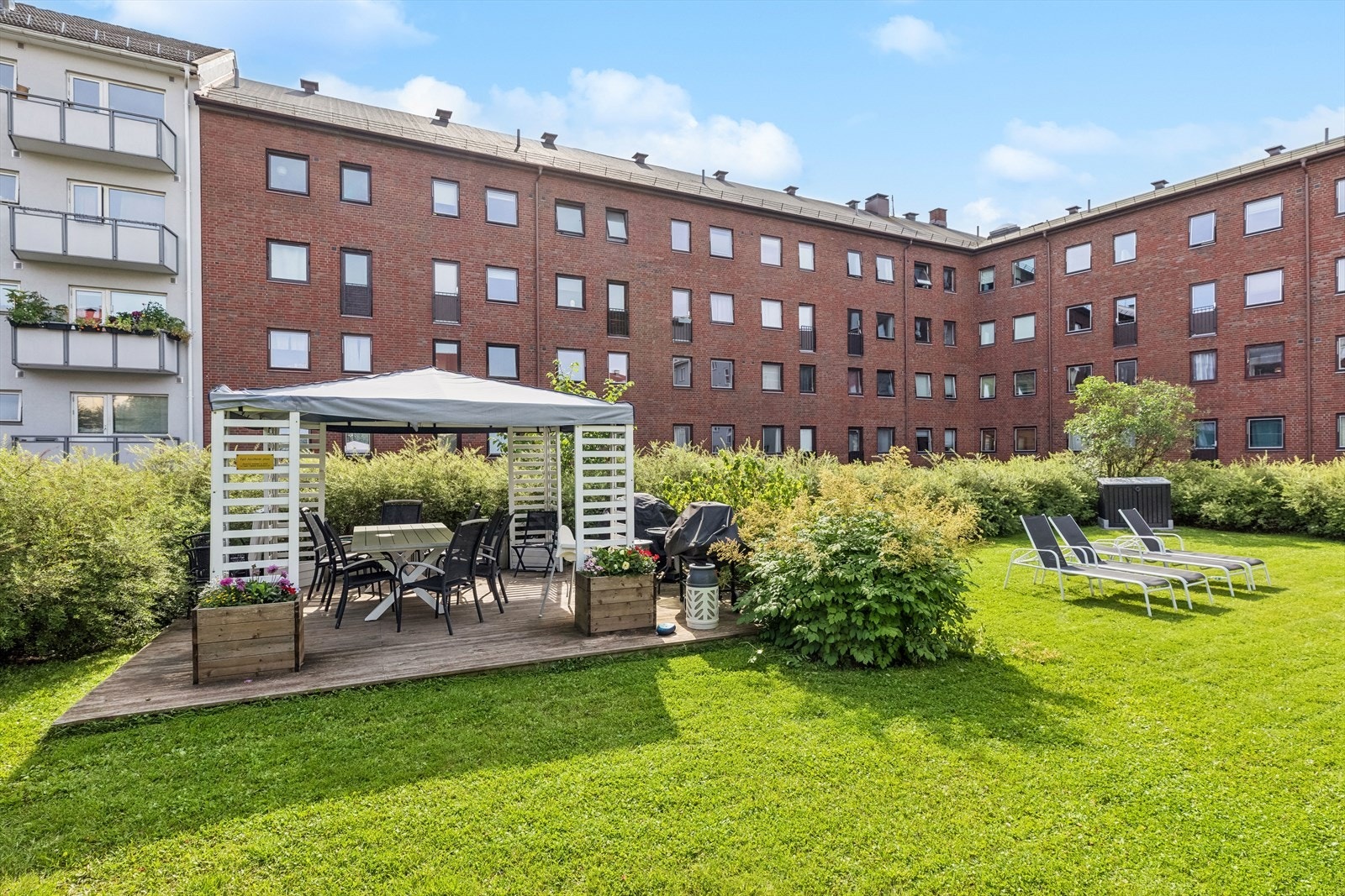 Frodig felles bakgård med flere hyggelige sittegrupper Galleribilde