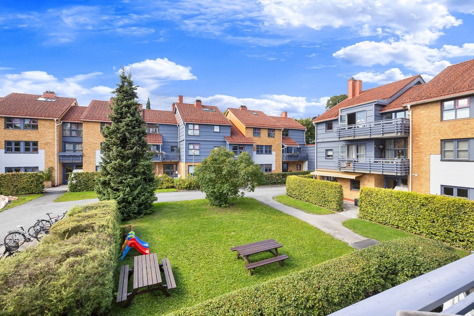 Utsyn mot parkmessige fellesarealer som strekker seg gjennom samtlige av sameiets tre bilfrie tun. Galleribilde