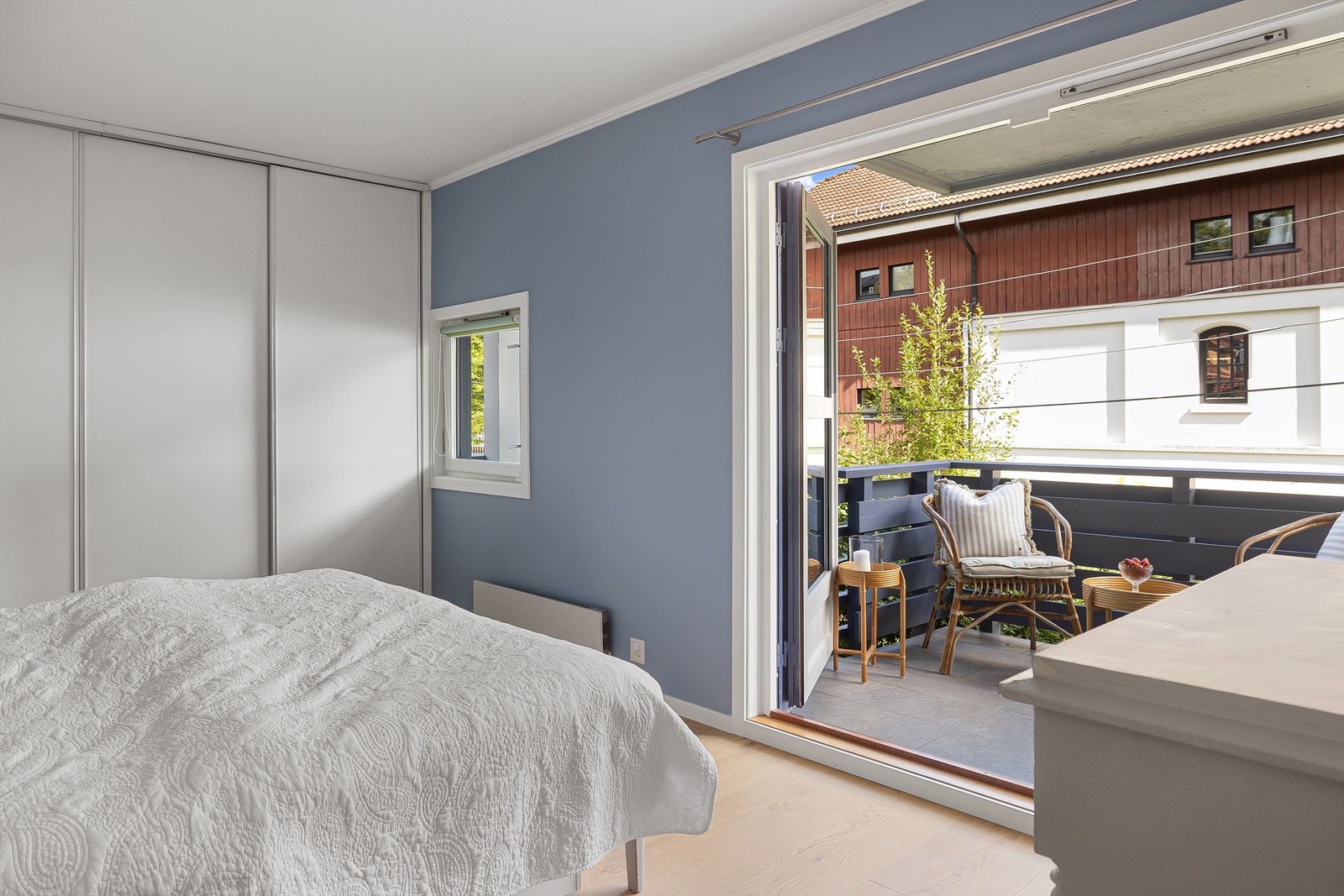 Balkongen vender mot sydøst og ser ut mot en tidligere sidebygning til et småbruk som i dag blant annet huser et galleri. Galleribilde