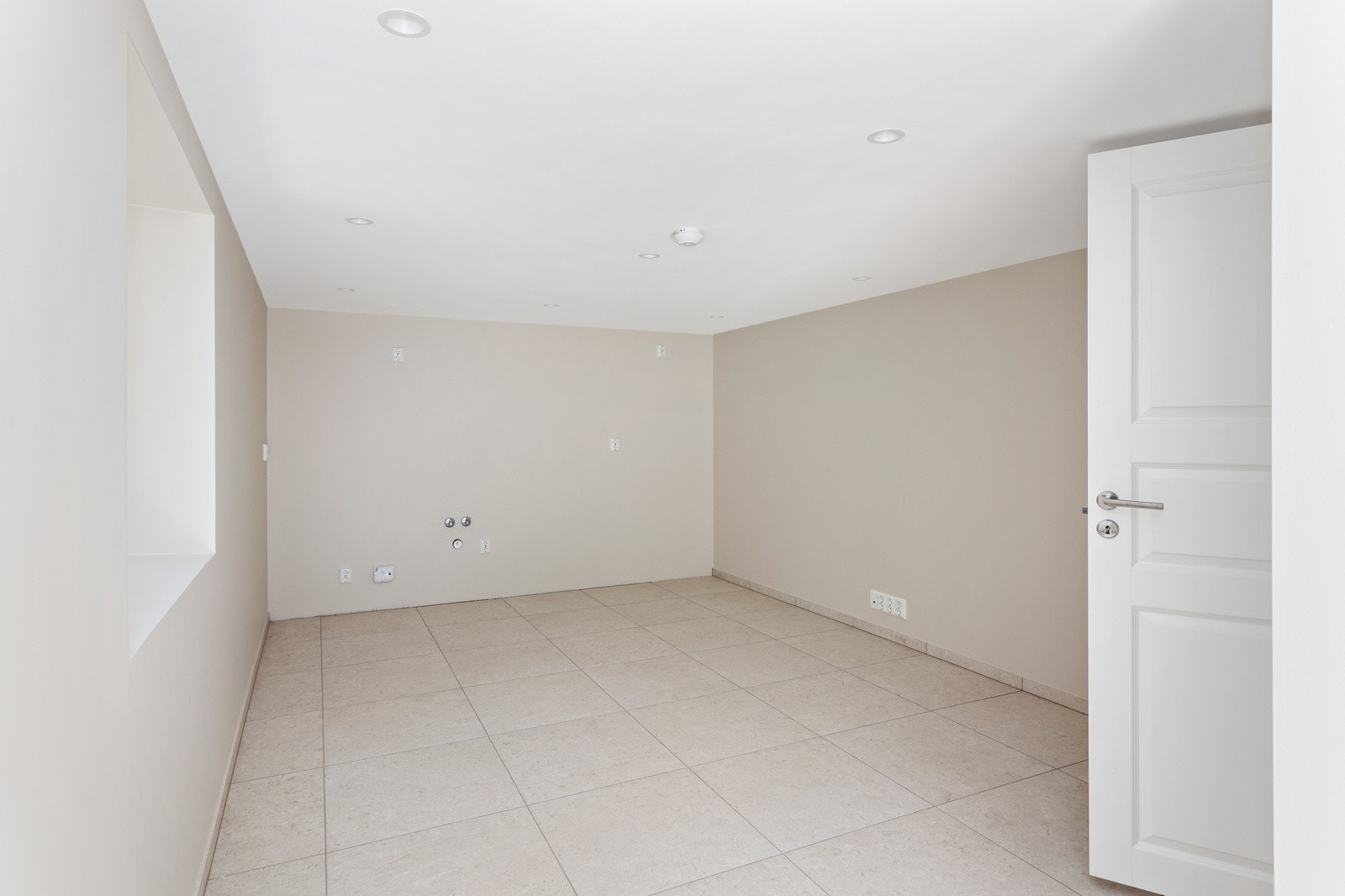 Kjelleretg: Pent innredet stort kjellerrom med vindu - opplegg for vann/avløp på vegg i rommet Galleribilde