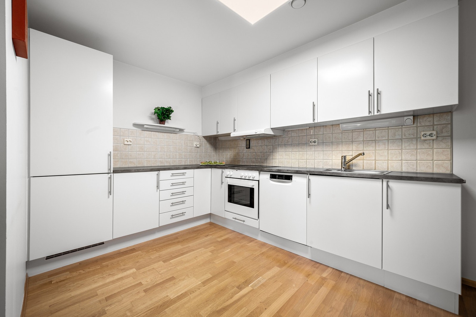 Tidløs kjøkkeninnredning med glatte fronter og benkeplate av laminat, meget god skap- og benkeplass Galleribilde