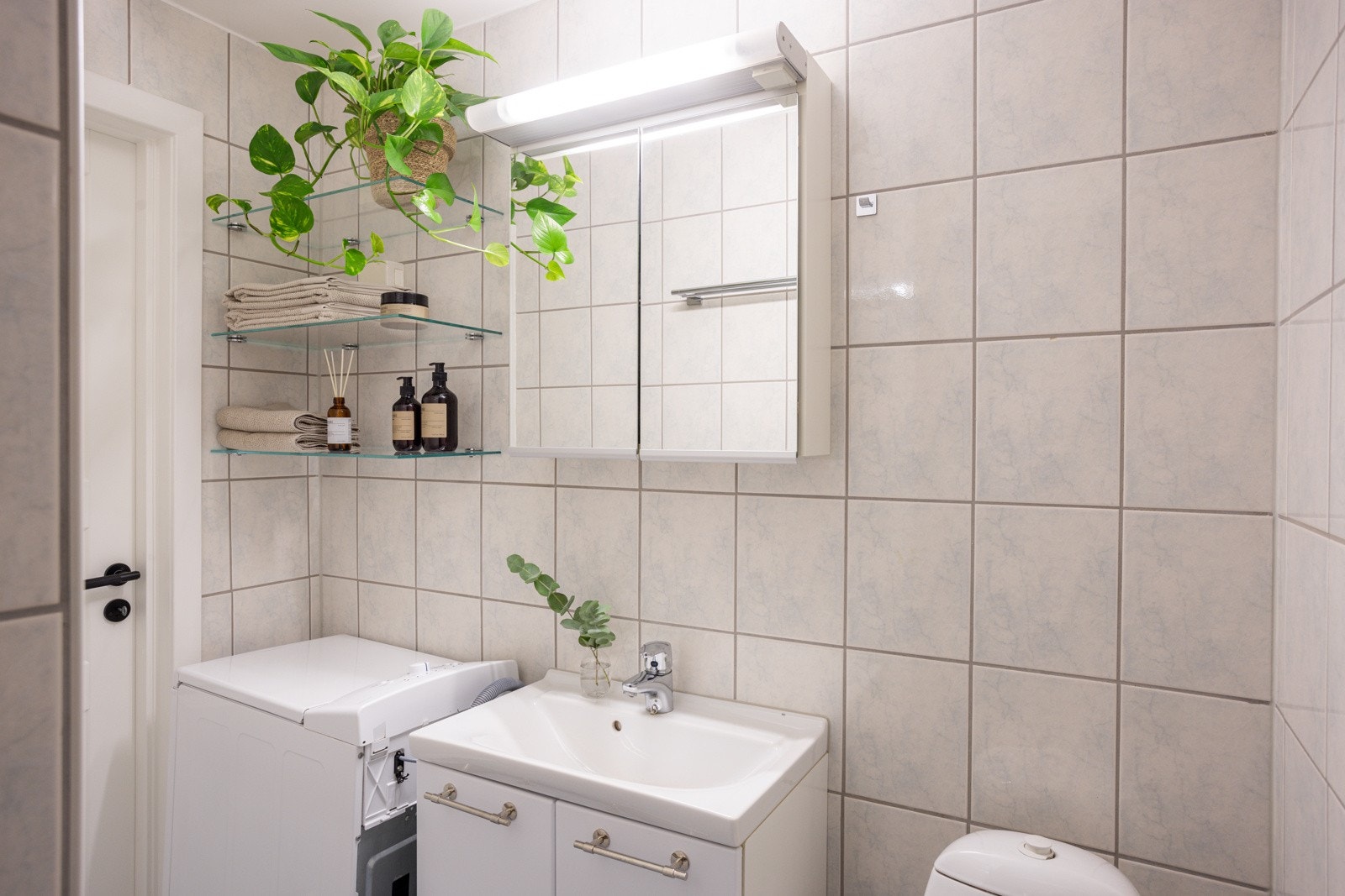 Badet har mye oppbevaring i åpne glasshyller, speilskap og servantskap. Galleribilde