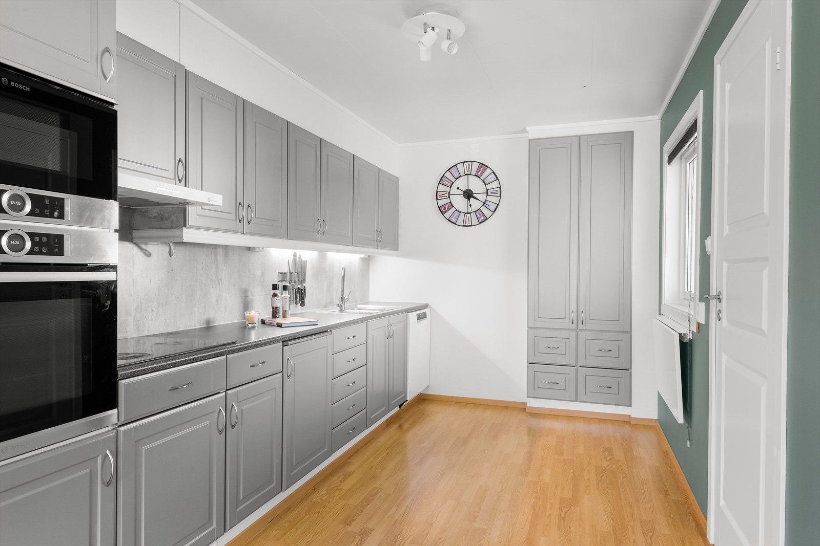 Kjøkkenet har de senere år vært frisket opp med en flott grå farge, nye håndtak, ny benkeplate, Kitchen Board mellom benk- og overskap. Galleribilde