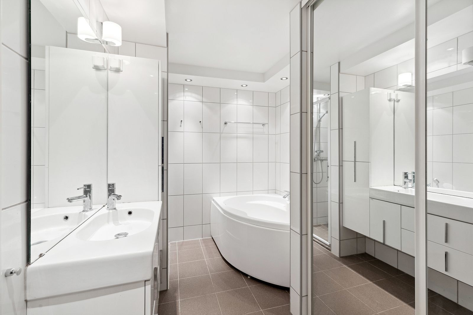 Delikat flislagt bad med opplegg til vaskemaskin, dusj og badekar Galleribilde