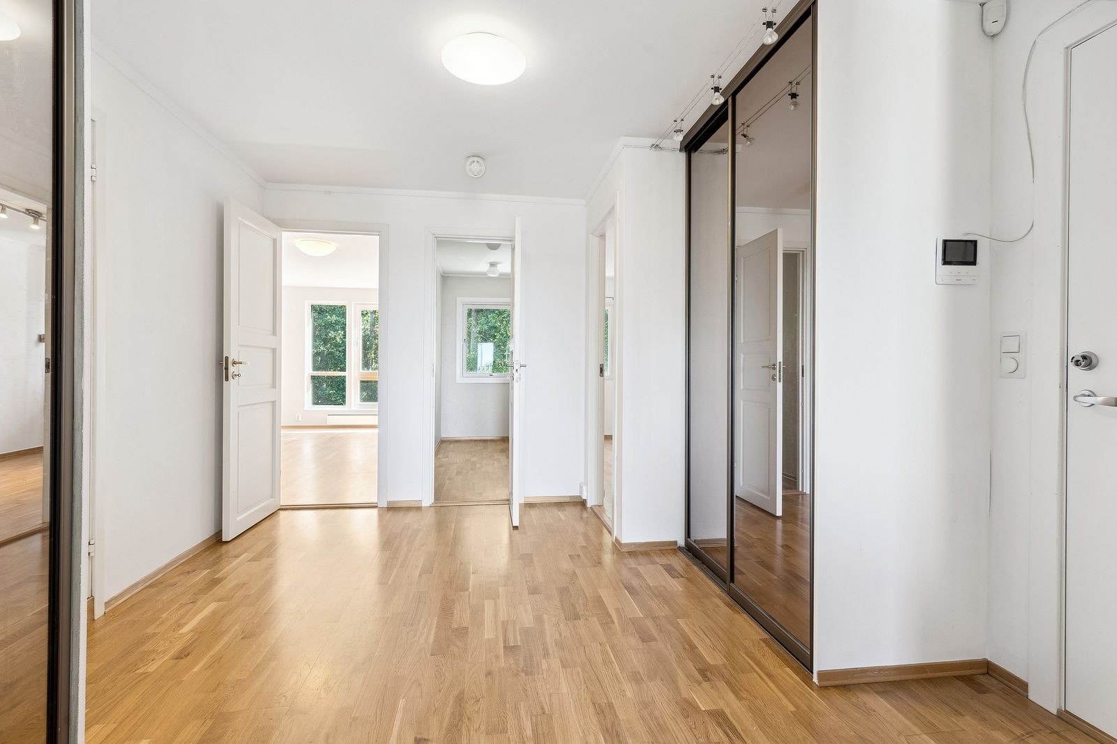 Stor entré med skyvedørsgarderober og inngang til boligens 3 soverom. Galleribilde