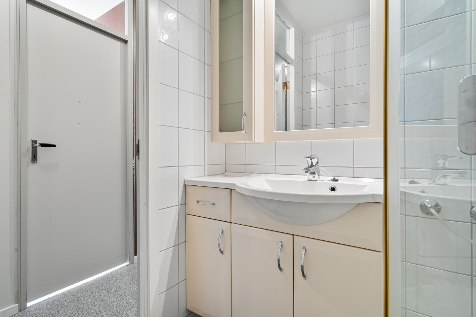 Badet er utstyrt med dusjkabinett og servant i skap. Galleribilde